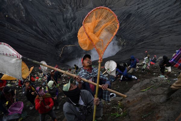 Dân làng dùng vợt hứng đồng xu ném vào miệng núi lửa trong buổi lễ đạo Hindu - Sputnik Việt Nam