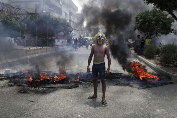 Một người đàn ông đeo mặt nạ chú hề tham gia cuộc biểu tình chống Chính phủ ở Beirut - Sputnik Việt Nam