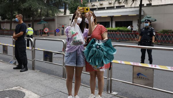 Các cô gái tđang chụp ảnh tự sướng bên ngoài Lãnh sự quán Hoa Kỳ ở Thành Đô, Trung Quốc. - Sputnik Việt Nam