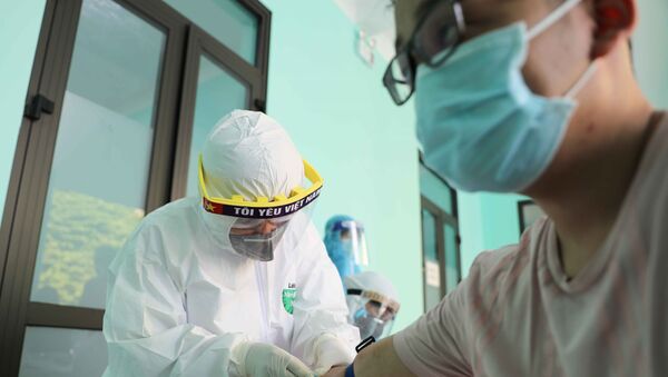 Nhân viên y tế lấy mẫu máu để xét nghiệm nhanh cho người dân tại Trạm Y tế phường Dịch Vọng, quận Cầu Giấy. - Sputnik Việt Nam