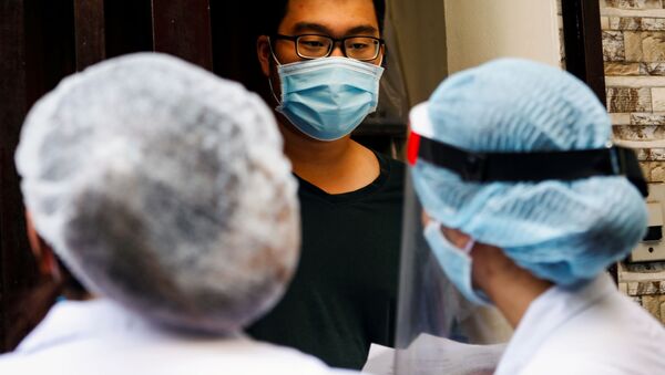 Nhân viên y tế trao đổi với người dân địa phương cạnh nhà của một bệnh nhân nhiễm coronavirus ở Hà Nội, Việt Nam. - Sputnik Việt Nam