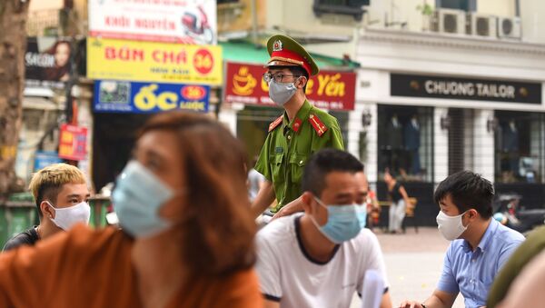Một cảnh sát đeo mặt nạ tại một trung tâm xét nghiệm coronavirus tại Hà Nội - Sputnik Việt Nam