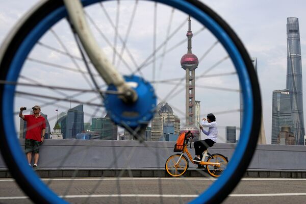 Những người đi xe đạp ở khu tài chính Lujiazui ở Thượng Hải - Sputnik Việt Nam