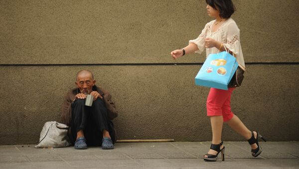 Một người đàn ông ăn xin trên phố khi một người phụ nữ đi ngang qua ở Thượng Hải - Sputnik Việt Nam
