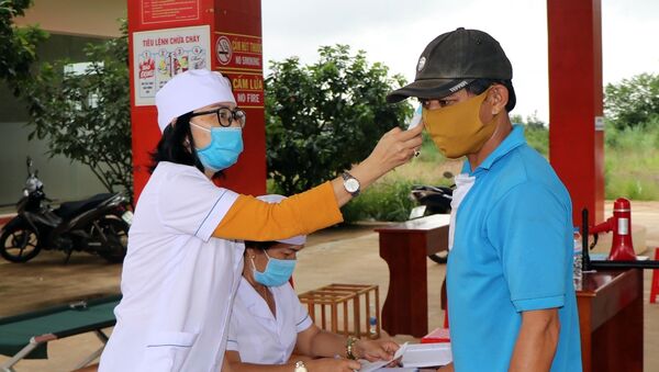 Nhân viên y tế kiểm tra thân nhiệt người tham gia giao thông tại Chốt kiểm tra Sao Mai. - Sputnik Việt Nam