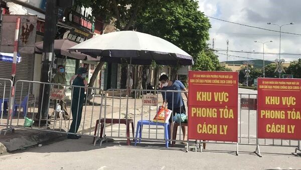 Người dân trong khu vực phong tỏa trên phố Ngô Quyền (Hải Dương) nhận thực phẩm tiếp tế tại hàng rào cách ly ngày 16/8 - Sputnik Việt Nam