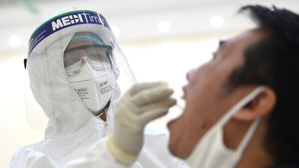 Nhân viên y tế của quận Cầu Giấy, Hà Nội tiến hành lấy mẫu dịch hầu họng để xét nghiệm bằng phương pháp RT-PCR của người dân từ Đà Nẵng trở về. - Sputnik Việt Nam