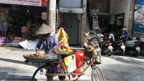 Người bán hàng dưới trời nắng nóng trên đường Tràng Thi. - Sputnik Việt Nam
