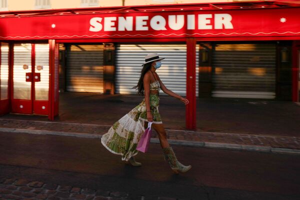 Cô gái đeo khẩu trang bảo vệ tại quán cà phê Le Cafe Senequier bên bờ sông ở Saint-Tropez, Pháp - Sputnik Việt Nam