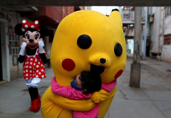 Tình nguyện viên trong trang phục Pikachu ôm đứa trẻ trong Ngày thiếu nhi ở Buenos Aires - Sputnik Việt Nam