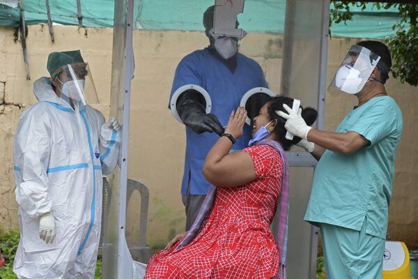 Lấy mẫu y phẩm cho người phụ nữ tại trung tâm xét nghiệm coronavirus COVID-19 miễn phí ở Hyderabad, Ấn Độ - Sputnik Việt Nam