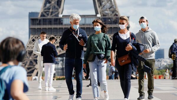 Người qua đường đeo khẩu trang y tế bảo vệ tại Tháp Eiffel ở Paris, Pháp - Sputnik Việt Nam