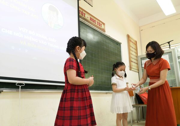 Học sinh lớp 1 trường Tiểu học Thịnh Liệt, quận Hoàng Mai (Hà Nội) được phổ biến, tuyên truyền, hướng dẫn phòng chống dịch cơ bản trong ngày đầu tới trường - Sputnik Việt Nam