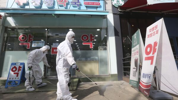 Nhân viên khử trùng trước một hiệu thuốc ở Hàn Quốc - Sputnik Việt Nam