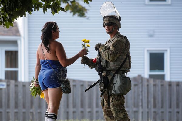 Người phụ nữ tặng hoa cho binh sĩ Vệ binh Quốc gia trong cuộc bạo loạn ở Wisconsin - Sputnik Việt Nam