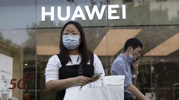 Cô gái đeo khẩu trang y tế trên nền của cửa hàng Huawei. Bắc Kinh - Sputnik Việt Nam