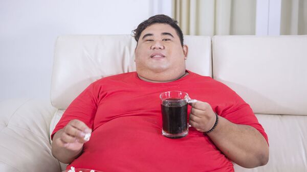 Người đàn ông béo phì với nước ngọt Coca Cola và bỏng ngô. - Sputnik Việt Nam