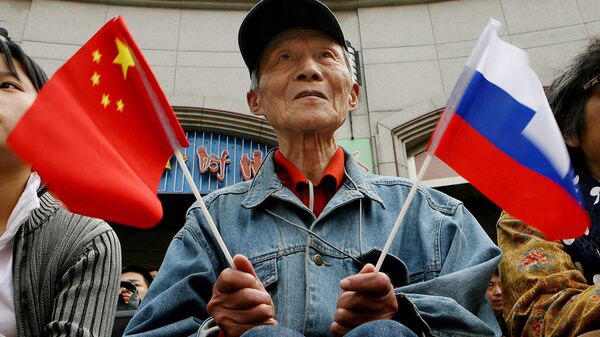 Người cao tuổi cầm cờ Trung Quốc và Nga - Sputnik Việt Nam
