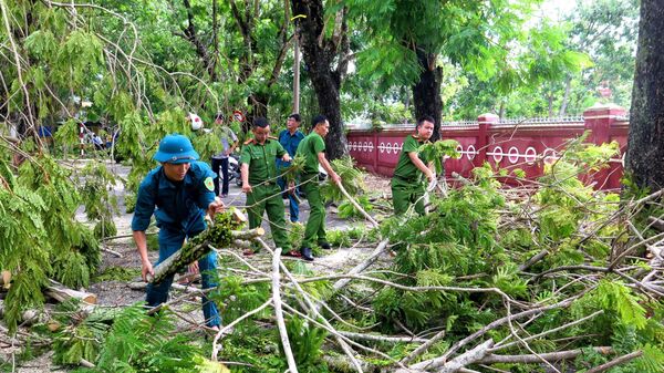 Lực lượng công an hỗ trợ dọn dẹp cây xanh bị ngã đổ. - Sputnik Việt Nam