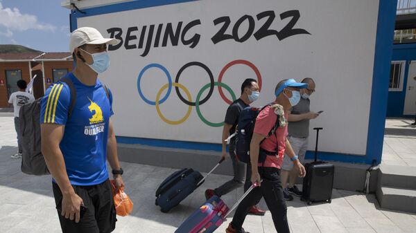 Khách du lịch trên nền biểu tượng của Thế vận hội Olympic Bắc Kinh 2022 - Sputnik Việt Nam