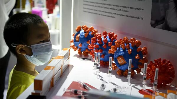 Một cậu bé nhìn vào việc lắp đặt vắc-xin và tế bào coronavirus tại triển lãm CIFTIS ở Bắc Kinh - Sputnik Việt Nam