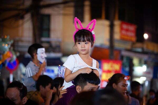 Một bé gái được bố cõng trên vai đưa đi chơi đêm Trung thu trên phố Hàng Mã. - Sputnik Việt Nam