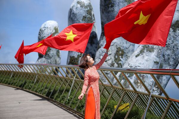 Giới trẻ thích thú được check-in trên Cầu Vàng với dãy cờ Tổ quốc tung bay - Sputnik Việt Nam