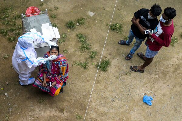 Nhân viên y tế lấy dịch mũi từ một phụ nữ để xét nghiệm coronavirus ở ngoại ô Hyderabad - Sputnik Việt Nam