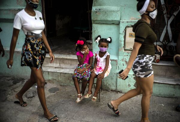 Bé gái đeo khẩu trang ngồi chờ bố mẹ ở Havana, Cuba - Sputnik Việt Nam