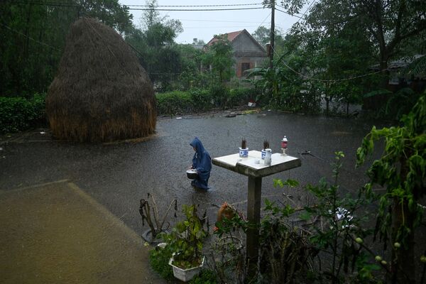 Người phụ nữ đường trên phố ngập nước gần nhà ở Việt Nam - Sputnik Việt Nam