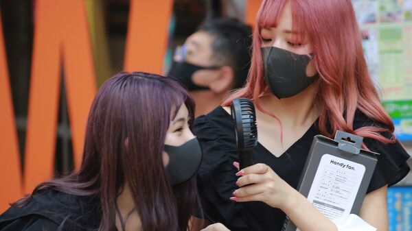 Các cô gái đeo khẩu trang ở Tokyo, Nhật Bản. - Sputnik Việt Nam