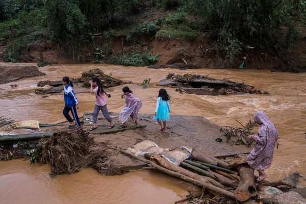 Trẻ em đi qua cây cầu bị sập sau trận lở đất ở tỉnh Quảng Trị, Việt Nam - Sputnik Việt Nam