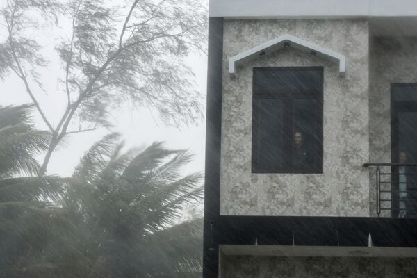 Người đàn ông bên cửa sổ trong cảnh mưa bão ở Việt Nam - Sputnik Việt Nam