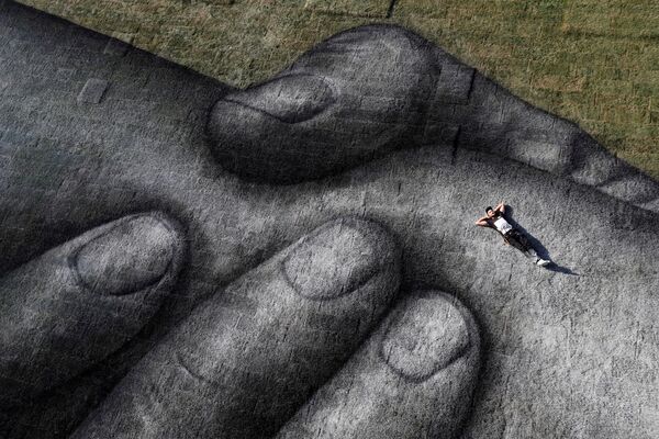 Nghệ sĩ Saype tạo dáng khi thực hiện tác phẩm của mình trên một sà lan nổi ở Istanbul, Thổ Nhĩ Kỳ - Sputnik Việt Nam