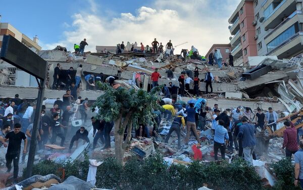 Lực lượng cứu hộ và cư dân địa phương sơ tán nạn nhân vụ sập nhà do hậu quả động đất ở tỉnh Izmir, Thổ Nhĩ Kỳ. - Sputnik Việt Nam