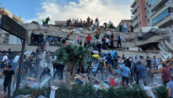 Lực lượng cứu hộ và cư dân địa phương sơ tán nạn nhân vụ sập nhà do hậu quả động đất ở tỉnh Izmir, Thổ Nhĩ Kỳ. - Sputnik Việt Nam