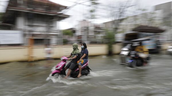 Những người bịt mặt đi xe máy trên đường phố ngập lụt ở Philippines - Sputnik Việt Nam