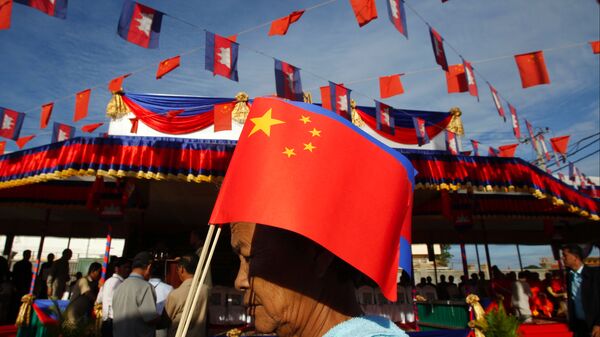 Người phụ nữ Campuchia với lá cờ Trung Quốc đi qua cầu Hữu nghị Campuchia-Trung Quốc trong lễ khai trương cầu này ở Tahmao - Sputnik Việt Nam