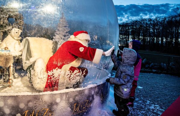 Ông già Noel giao tiếp với trẻ em khi ngồi trong bong bóng khổng lồ tại vườn thú ở Aalborg, Đan Mạch - Sputnik Việt Nam