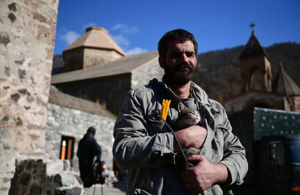 Người đàn ông ôm con mèo trên tay gần tu viện Dadivank ở Nagorno-Karabakh - Sputnik Việt Nam