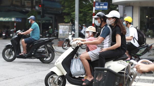Cặp đôi đeo khẩu trang y tế đi xe máy ở Hà Nội, Việt Nam - Sputnik Việt Nam