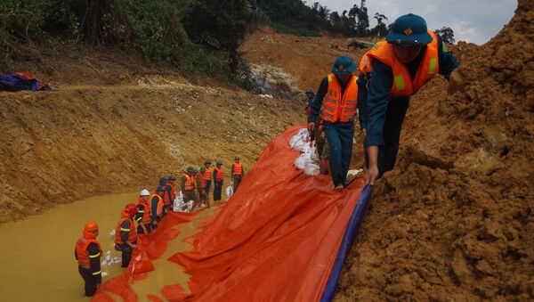 Lực lượng cứu hộ nỗ lực hoàn thành việc nắn sông để sớm tìm kiếm các nạn nhân dưới lòng sông Rào Trăng. - Sputnik Việt Nam