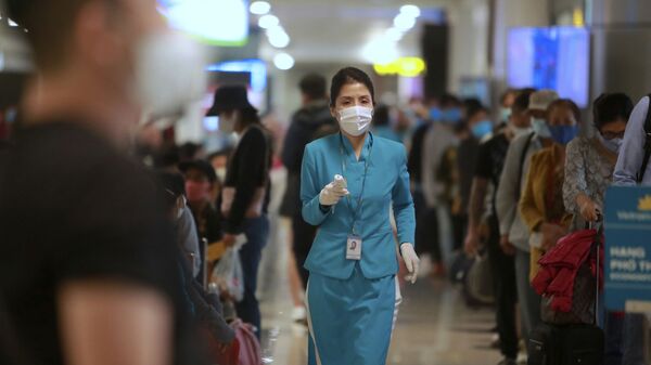 Nhân viên hàng không cầm nhiệt kế tại sân bay Hà Nội, Việt Nam - Sputnik Việt Nam