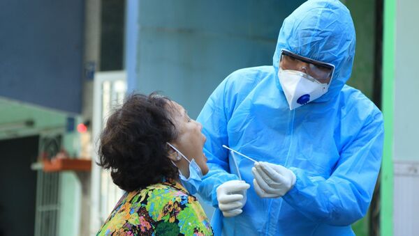 Nhân viên y tế lấy mẫu xét nghiệm người dân trong khu vực Lô E, Lò Gốm (Phường 7, Quận 6). Ảnh: Đinh Hằng - TTXVN - Sputnik Việt Nam