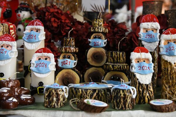 Những cây nến Giáng sinh hình ông già Noel Santa Claus đeo khẩu trang trong cửa hàng ở Hy Lạp - Sputnik Việt Nam