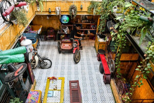 Nhân viên pha chế ngồi trên chiếc mô tô ba bánh cũ tại quán cà phê Việt Nam Hidden Gem Coffee ở Hà Nội - Sputnik Việt Nam