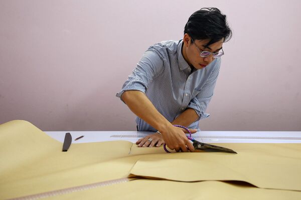Doanh nhân Nguyễn Đức Lộc đang nghiên cứu tạo mẫu cổ phục trên cơ sở mô-tip truyền thống ở Hà Nội  - Sputnik Việt Nam
