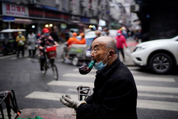 Người đàn ông lớn tuổi hút tẩu trong chợ đường phố ở Vũ Hán - Sputnik Việt Nam