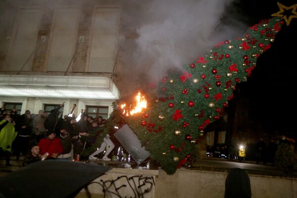 Người biểu tình đốt cây thông Noel trước dinh thủ tướng Albania trong cuộc đụng độ ở Tirana - Sputnik Việt Nam