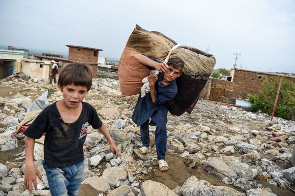 Thanh niên cứu những đồ đạc còn sót lại từ những ngôi nhà đống đổ nát sau trận lũ quét ở Charikar, tỉnh Parwan, Afghanistan - Sputnik Việt Nam